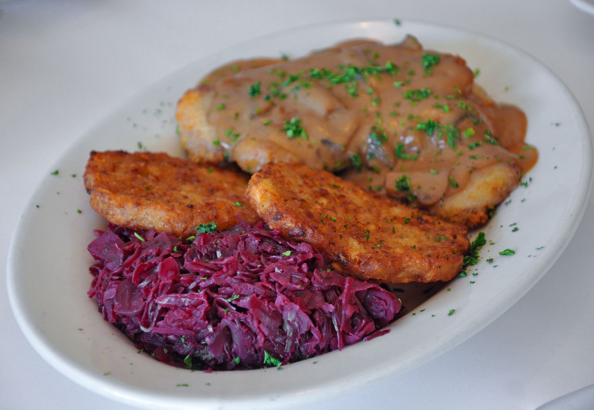 A plate of food with meat and sauce on a table.