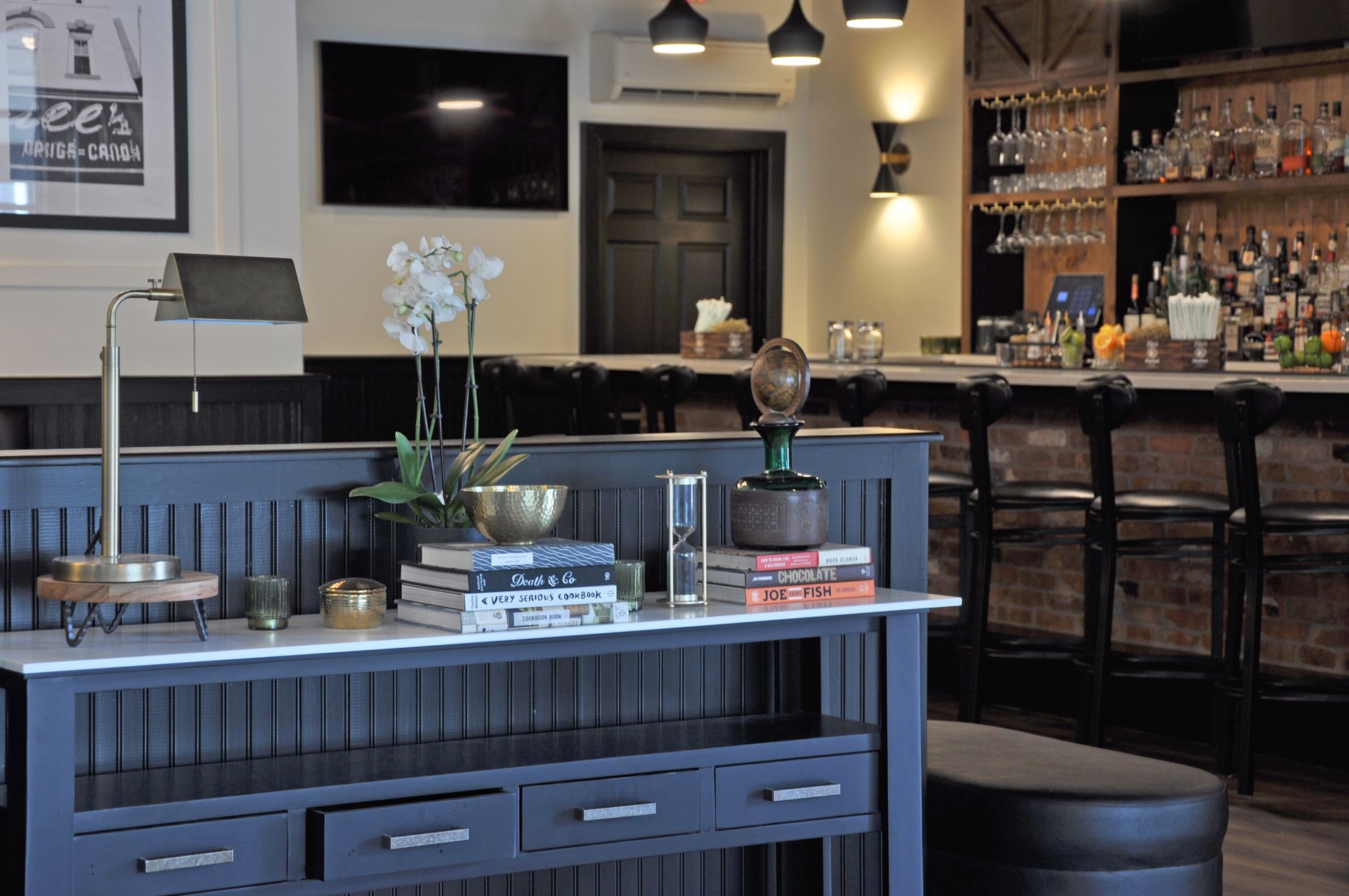 A table in a restaurant with a lamp and books on it