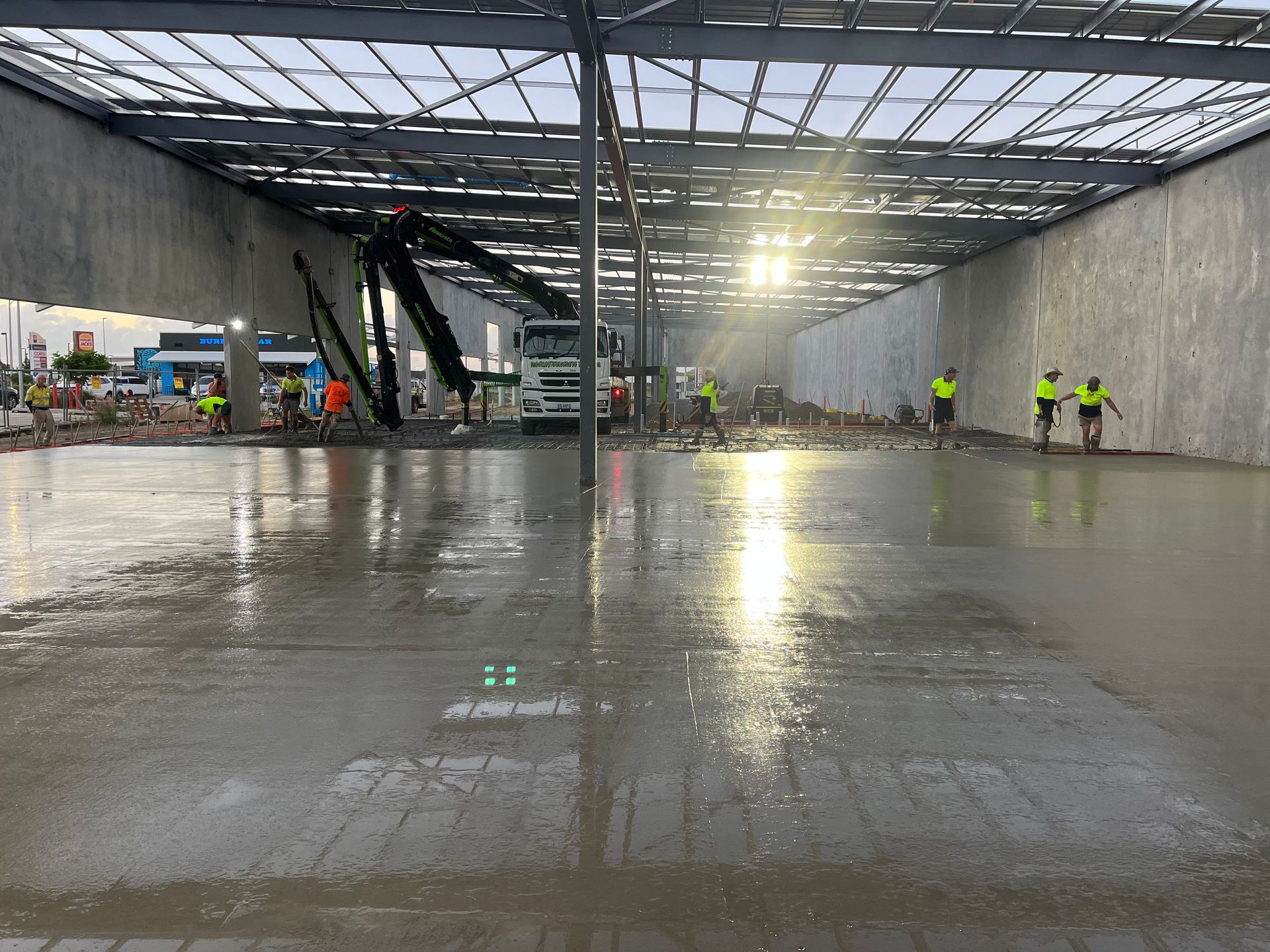 A Group Of People Are Working On A Concrete Floor In A Building — Mass Construction Group Australia Pty Ltd in South Mackay, QLD