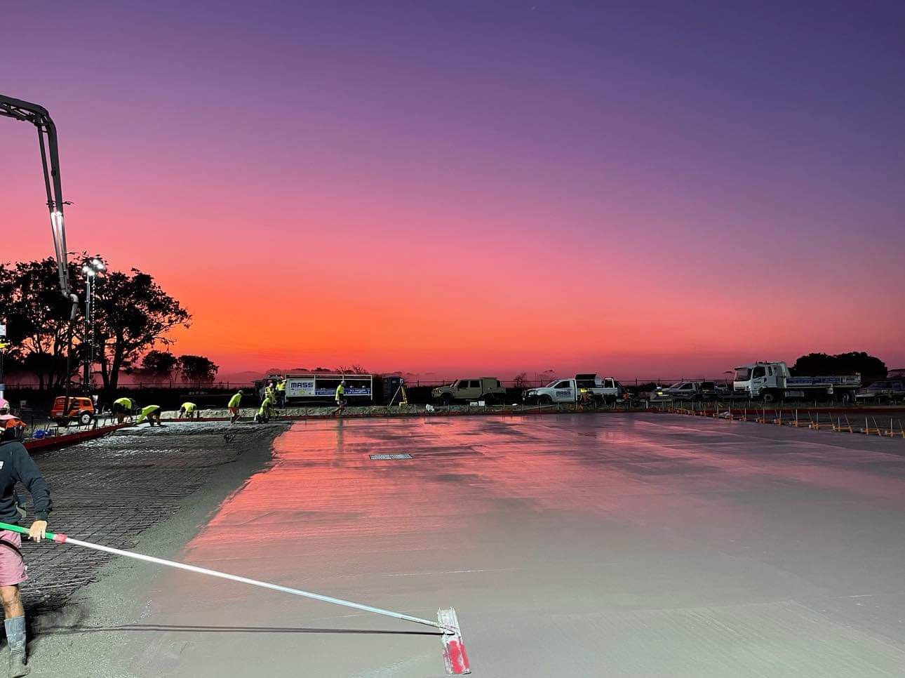 A Man Is Walking Across a Concrete Surface with A Sunset — Mass Construction Group Australia Pty Ltd in South Mackay, QLD