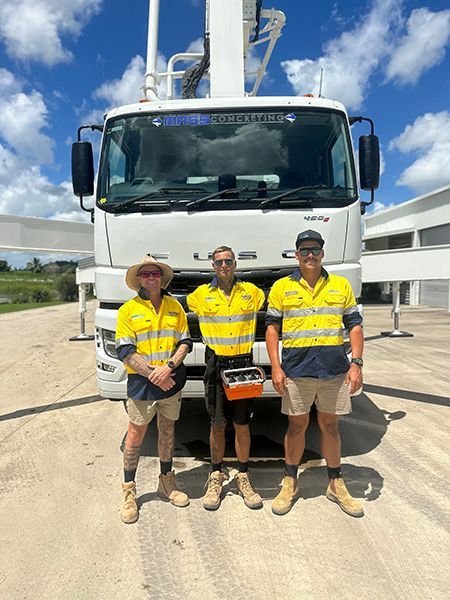 Three Men Are Standing in Front of A White Truck — Mass Construction Group Australia Pty Ltd in South Mackay, QLD