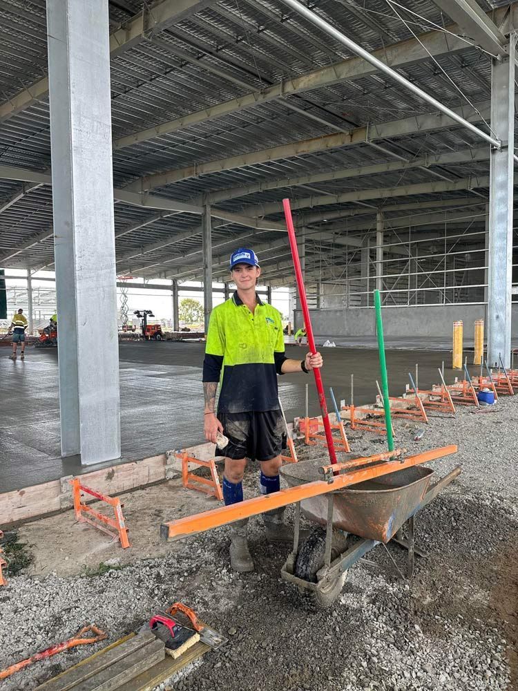 A Construction Worker Is Standing Next to A Wheelbarrow — Mass Construction Group Australia Pty Ltd in South Mackay, QLD