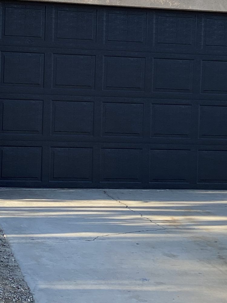 Dark blue garage door on a concrete driveway.