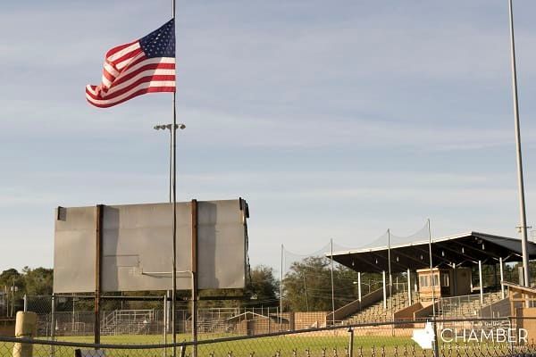 An american flag is flying in front of a stadium