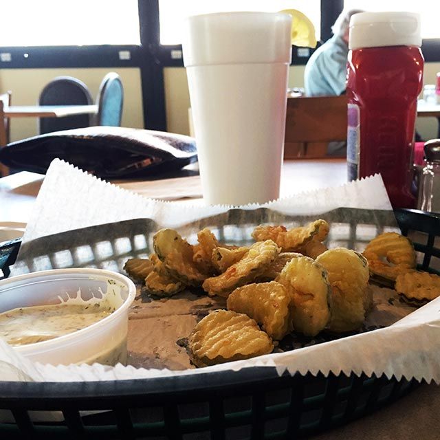 A basket of chips and a cup of ketchup on a table