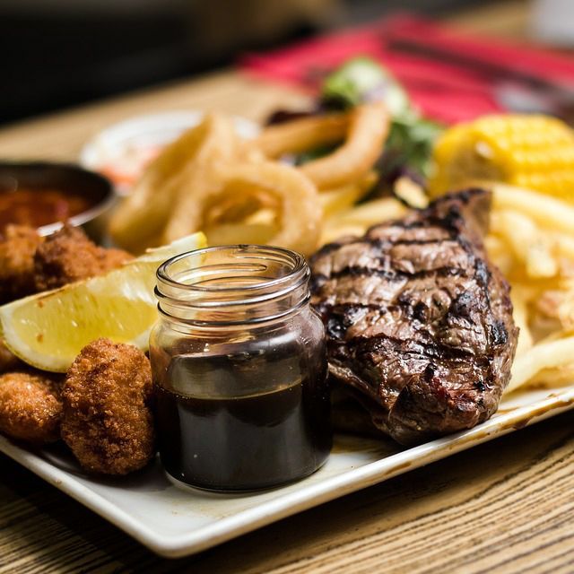 A plate of food with a jar of sauce on it