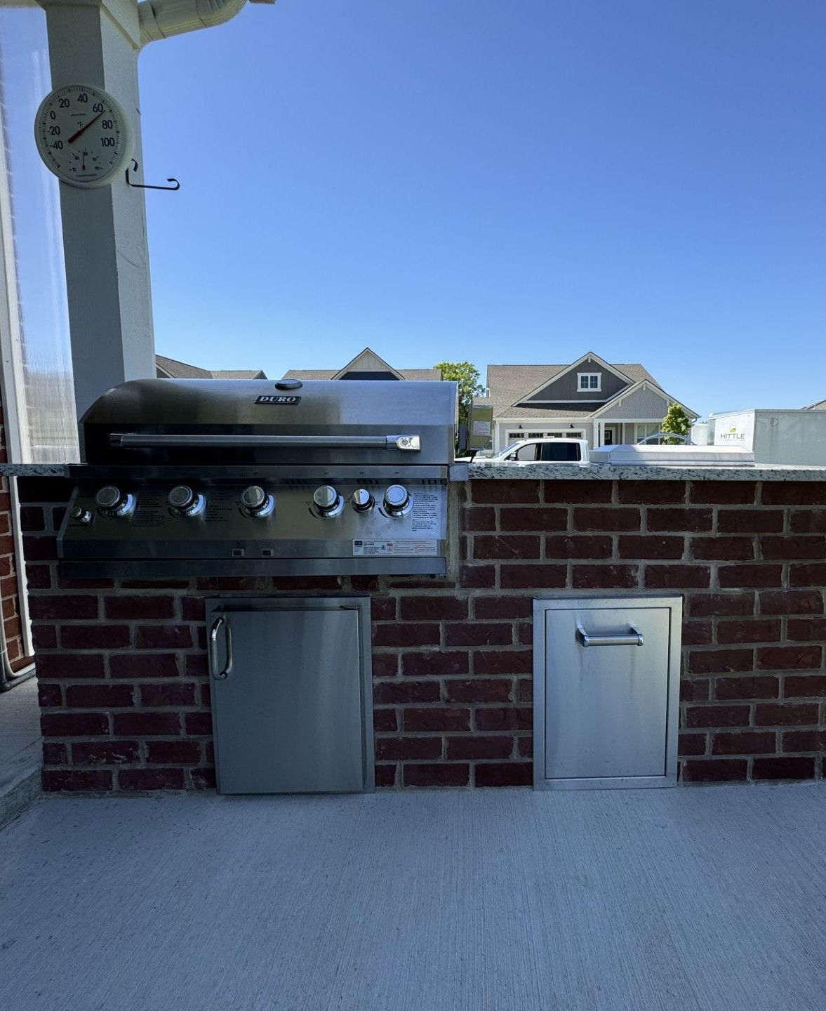 A brick wall with a grill and a clock on it