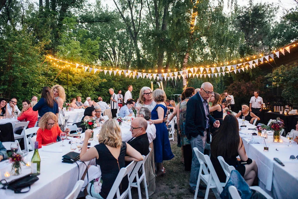 A large group of people are sitting at tables at a party.