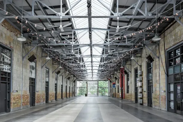 A large empty building with a lot of windows and lights hanging from the ceiling.