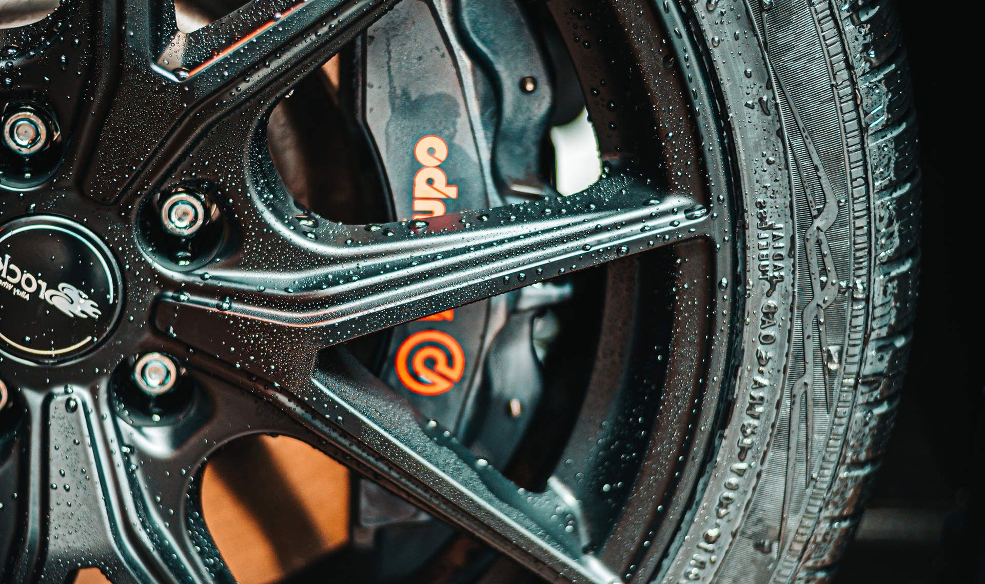 A close up of a car wheel with a brembo brake and a tire.