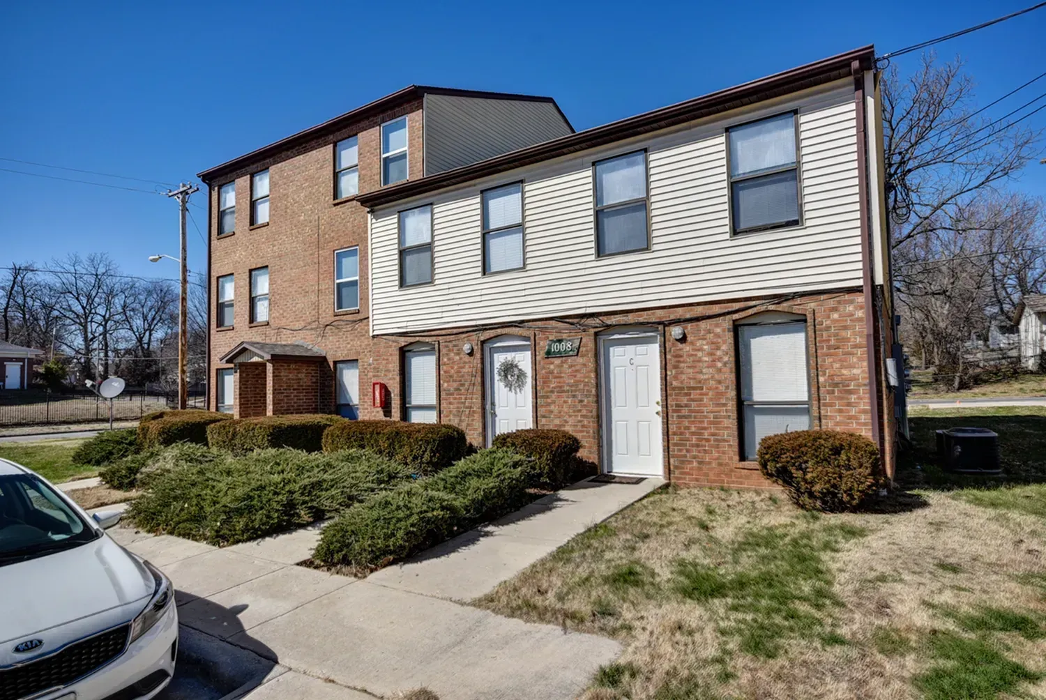 Photo of a multi-story apartment building, with sidewalks leading to the front doors