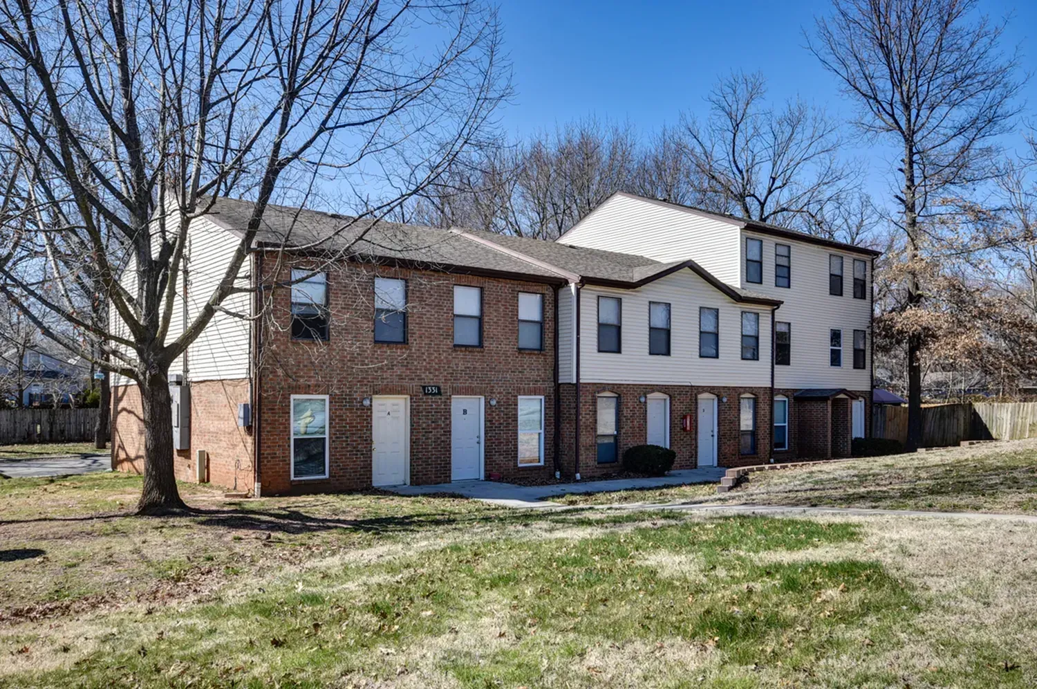 Photo of a row of apartments with a grassy area surrounding it