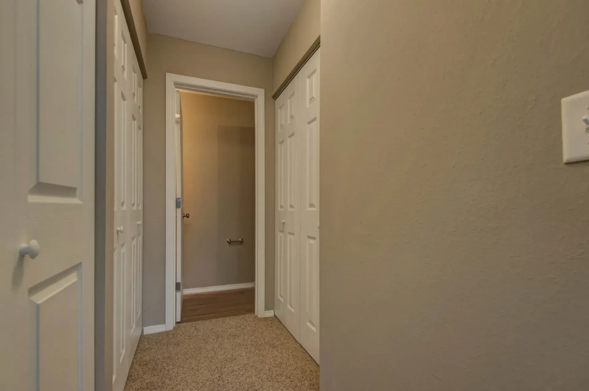 Photo of a hallway with an open door at the end