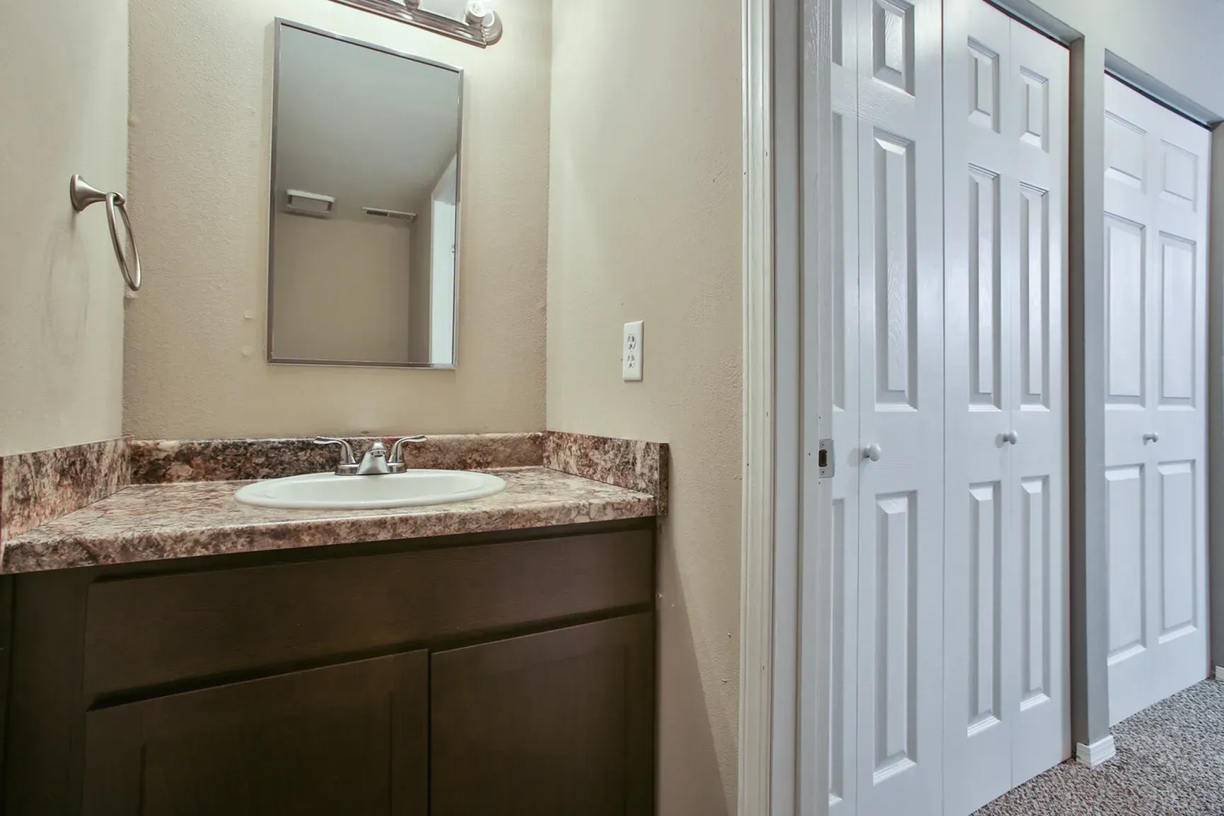Photo of a bathroom sink, with an vanity mirror