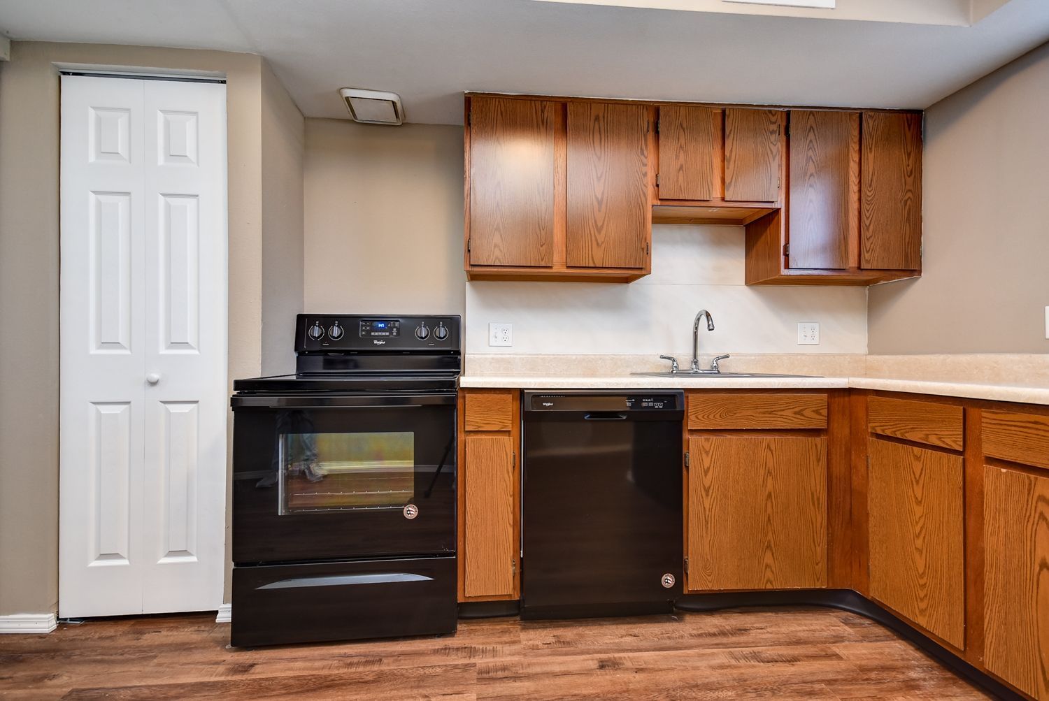 Photo of an L-shaped kitchen, with a pantry door
