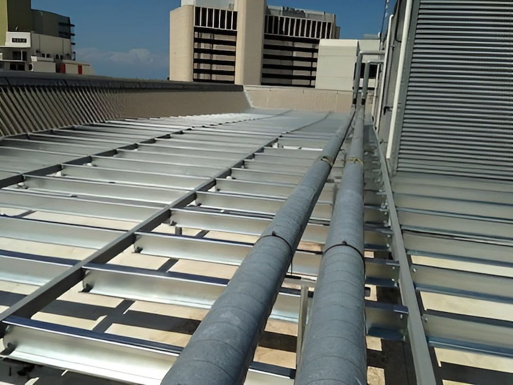 A Row Of Metal Pipes On A Roof With Buildings — Jakes Steel & Welding in East Arm, NT