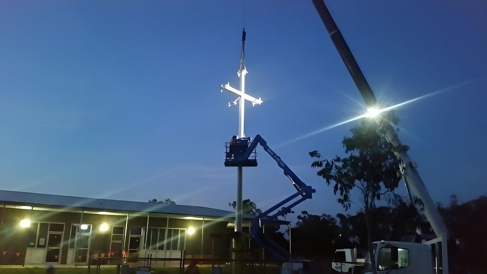 A Crane Is Lifting A Large Cross Into The Air — Jakes Steel & Welding in East Arm, NT