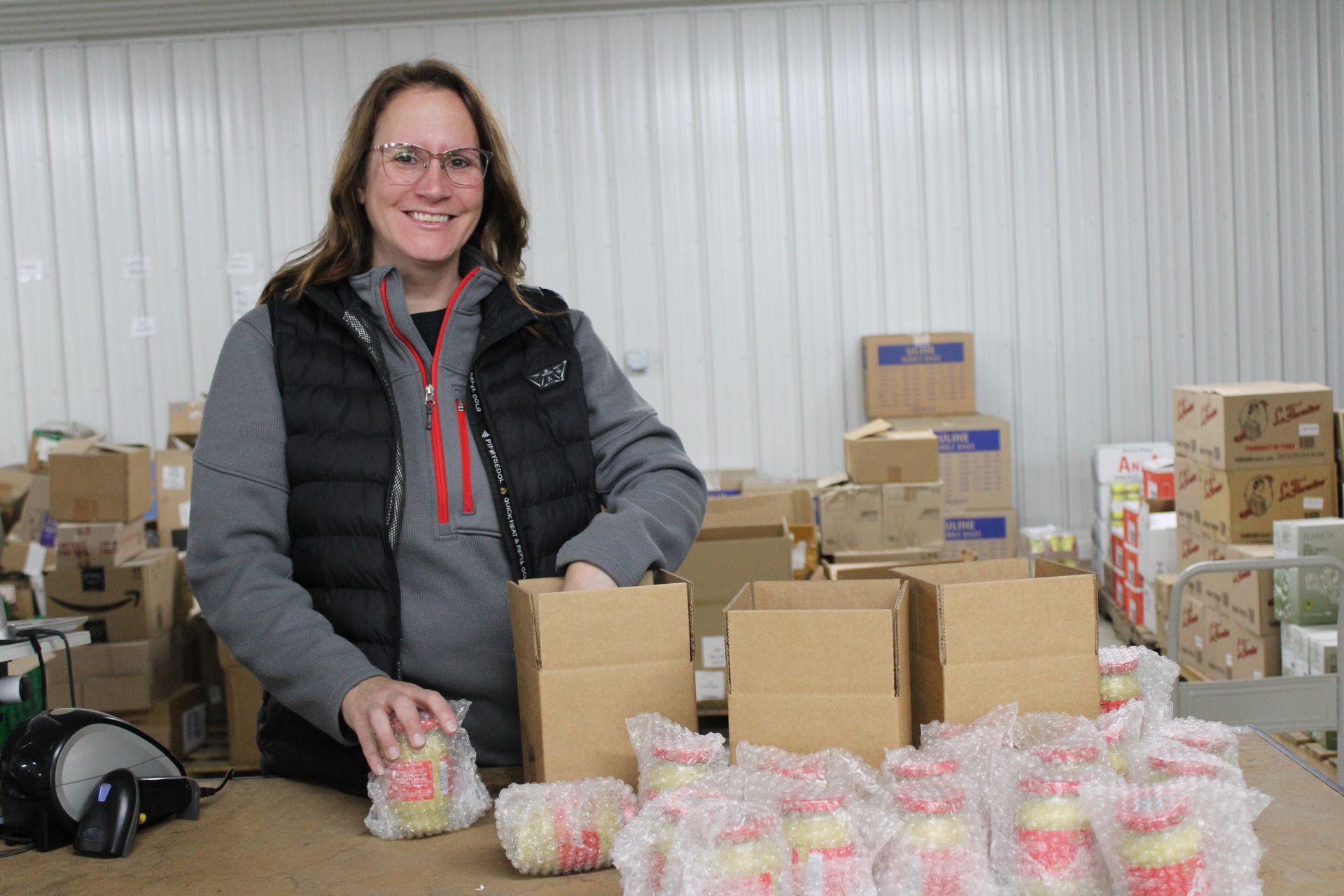 A row of white semi trucks are parked in a parking lot.