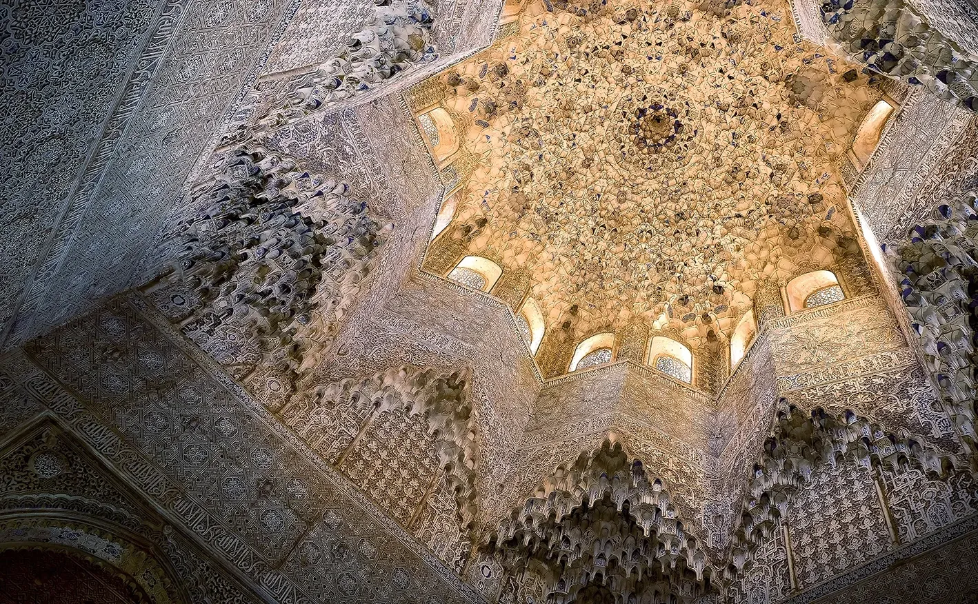 Intricate star-shaped ceiling with detailed stucco work, part of a building interior.