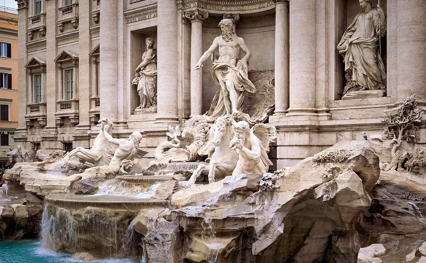 Trevi Fountain in Rome with Neptune statue and cascading water.