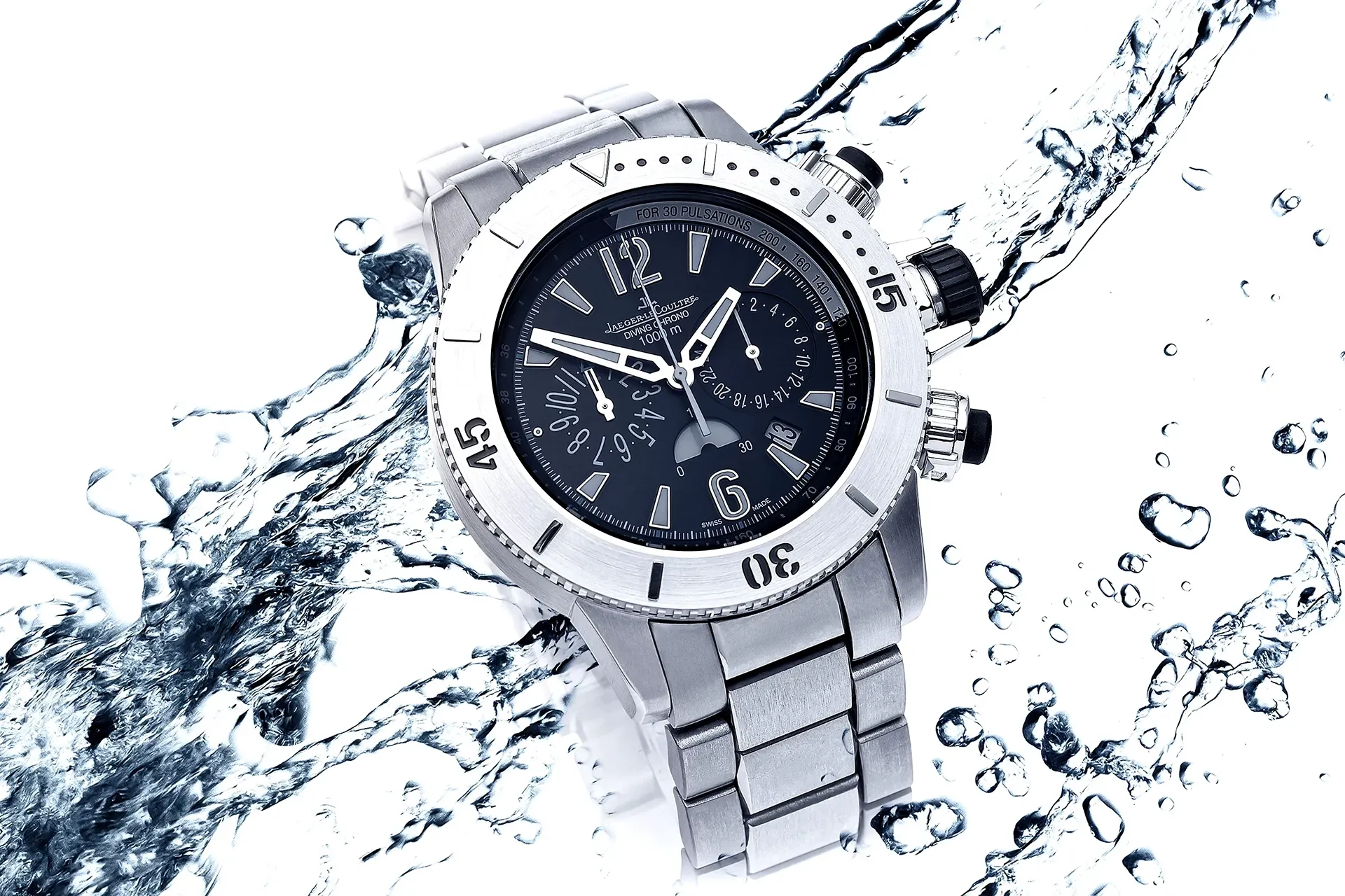 Silver wristwatch with black face, surrounded by water droplets.