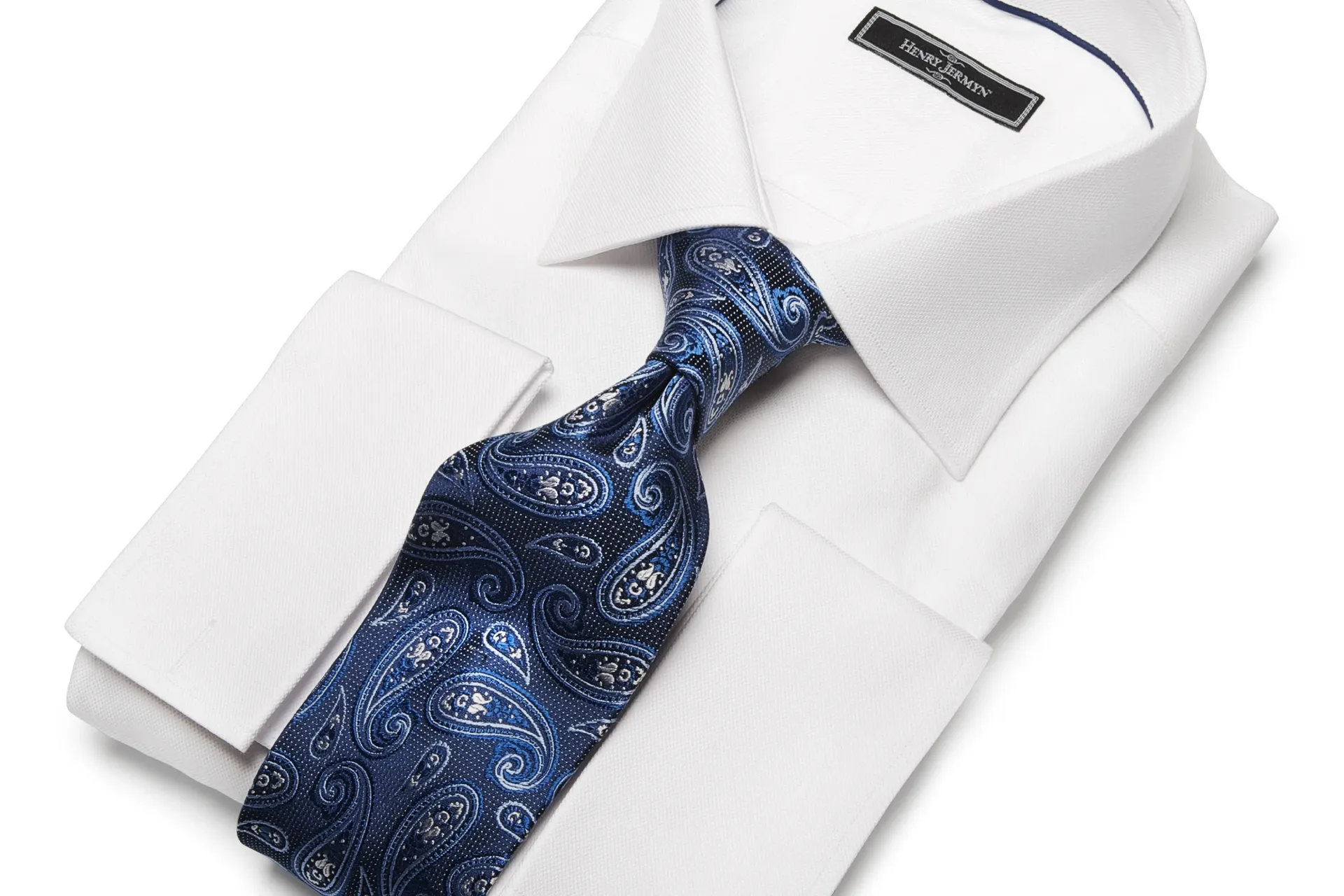 White dress shirt with a blue paisley tie.