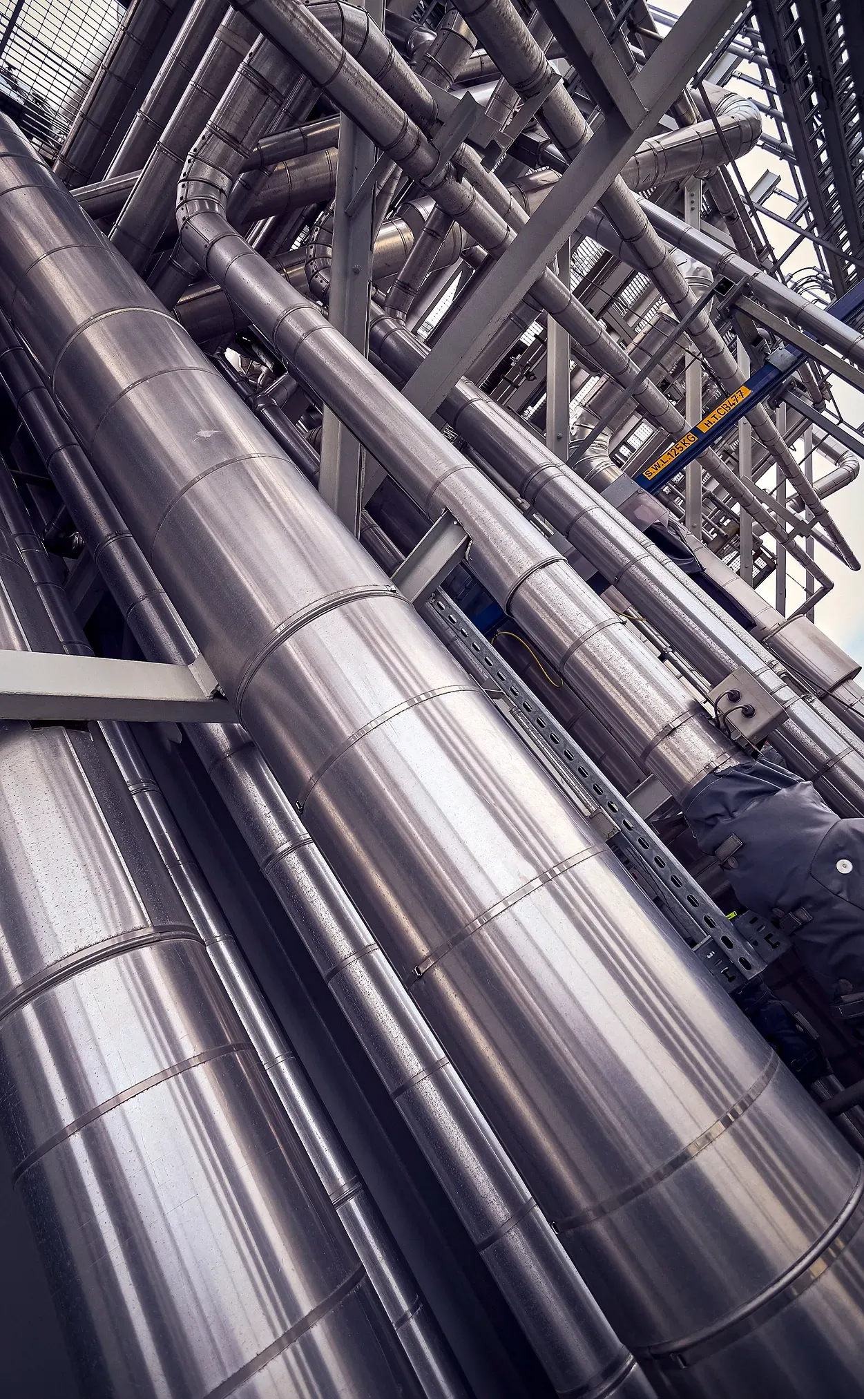 Stainless steel pipes and metal framework in an industrial setting.