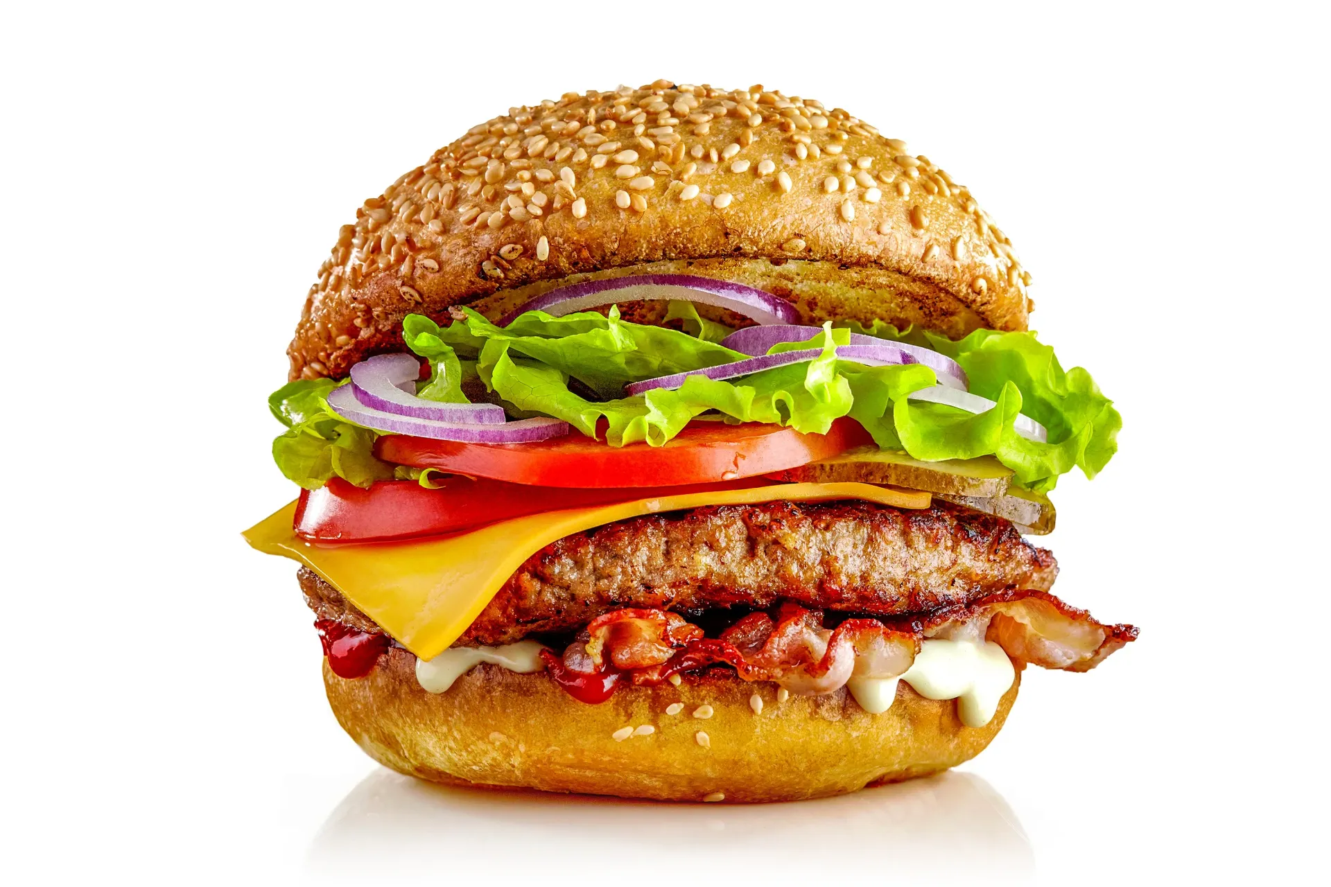 Burger with sesame seed bun, lettuce, tomato, red onion, cheese, bacon, and patty.