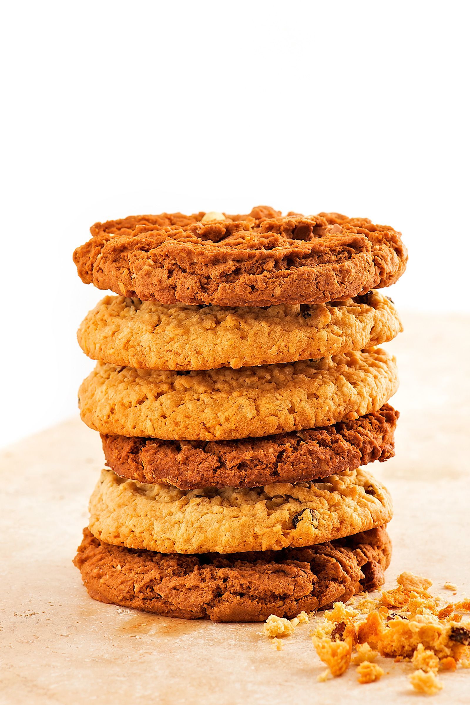 Stack of six golden brown oatmeal cookies on parchment paper.