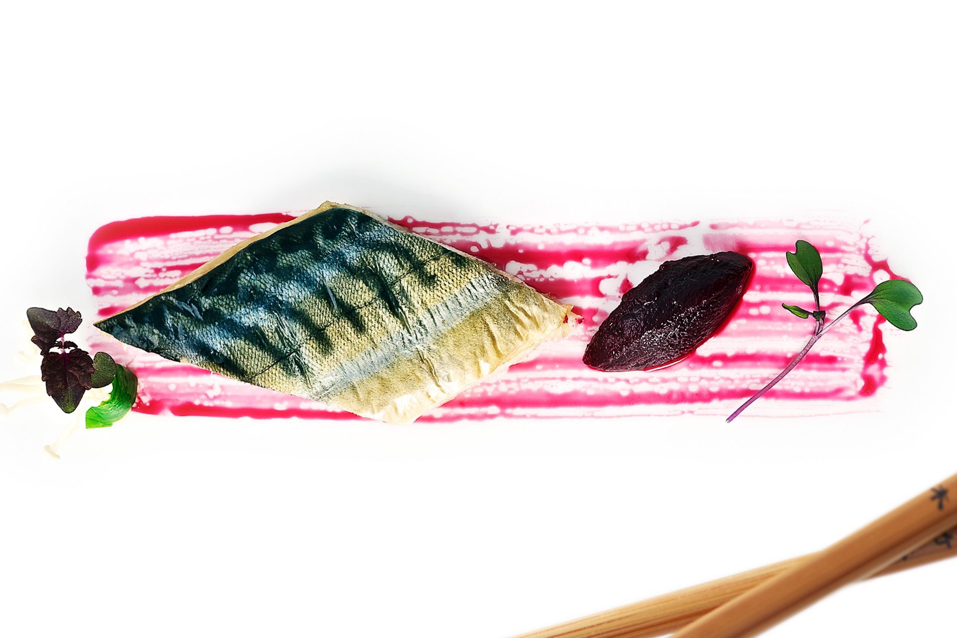 Grilled fish on pink puree with beet and greens, chopsticks.