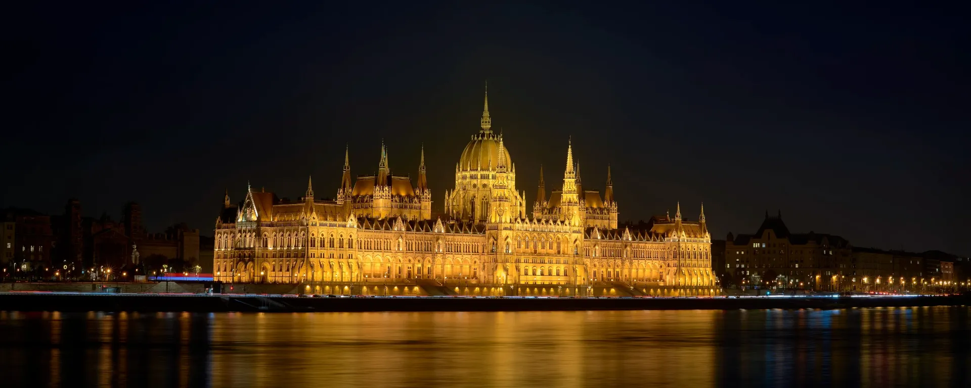 Night view of the illuminated Hungarian Parliament Building on the Danube River.