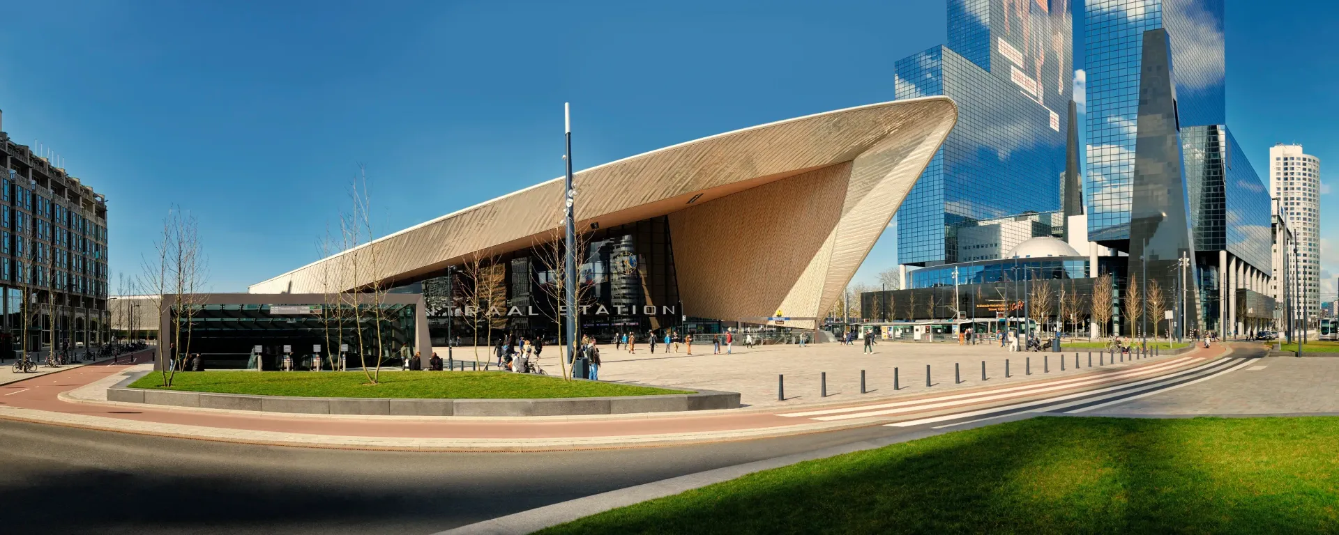 Modern building with angled roof, glass facade, and blue sky.