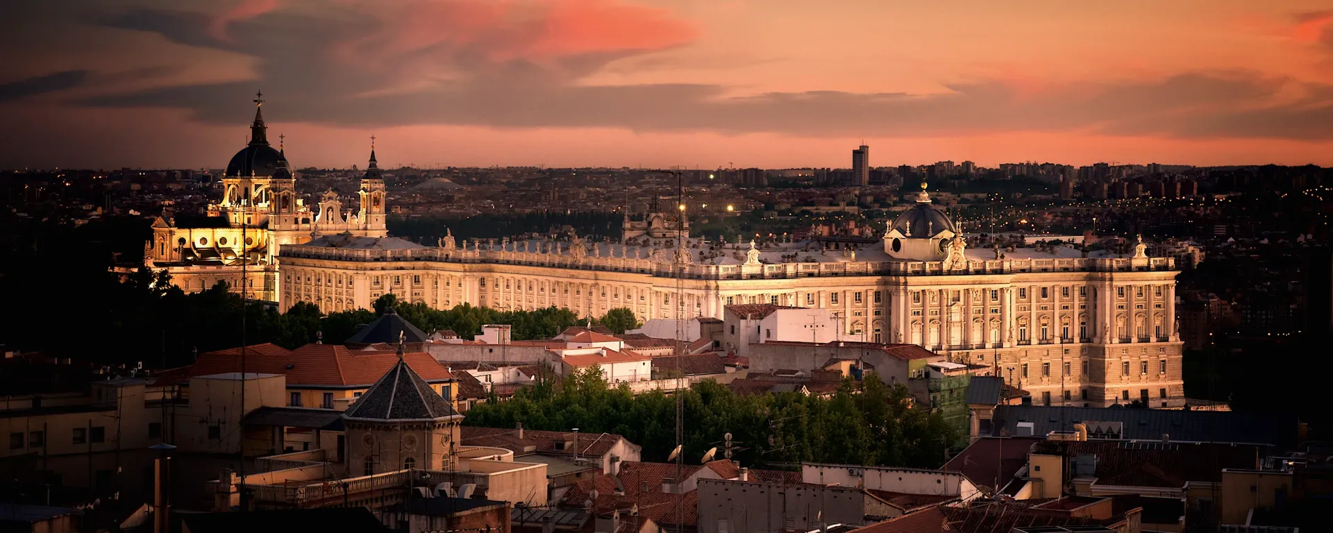 View of the illuminated Royal Palace of Madrid at sunset.