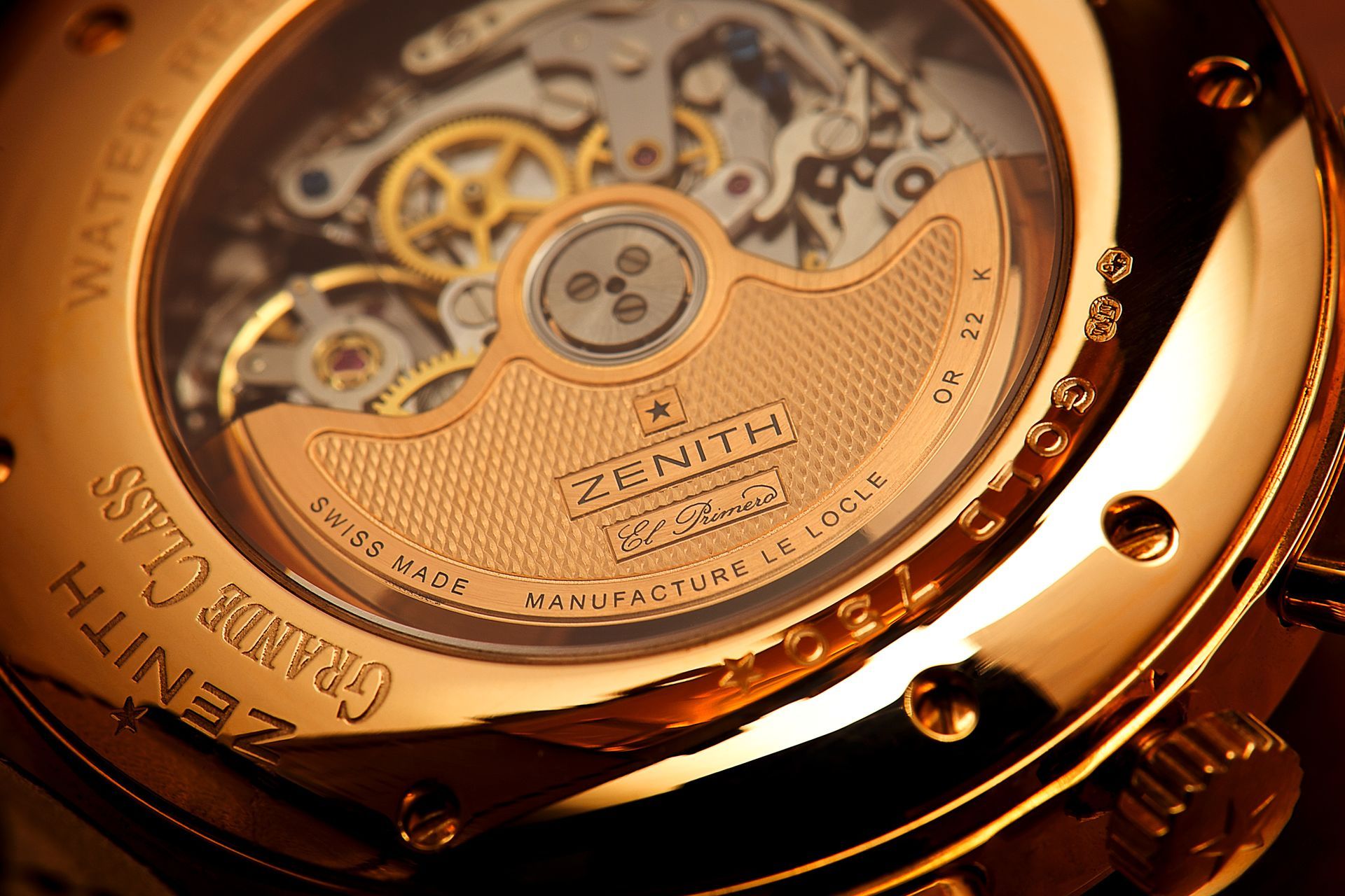 Close-up of a Zenith Grande Class watch back, revealing the intricate movement and gold-colored details.