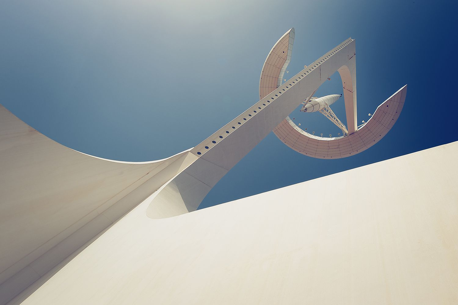 White modernist sculpture against a clear, blue sky.