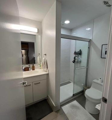 A Bathroom With a Toilet, Sink, Shower and Mirror