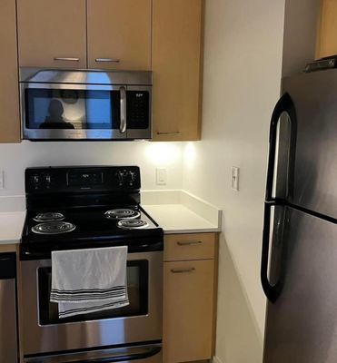 A Kitchen With a Stove Top Oven a Microwave and a Refrigerator