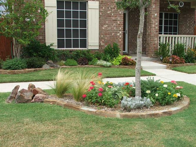 Landscaped garden with flowers in the middle of a green lawn