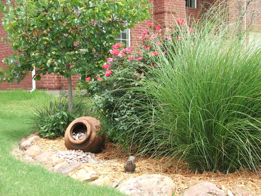 landscaped garden with an urn besides a green lawn
