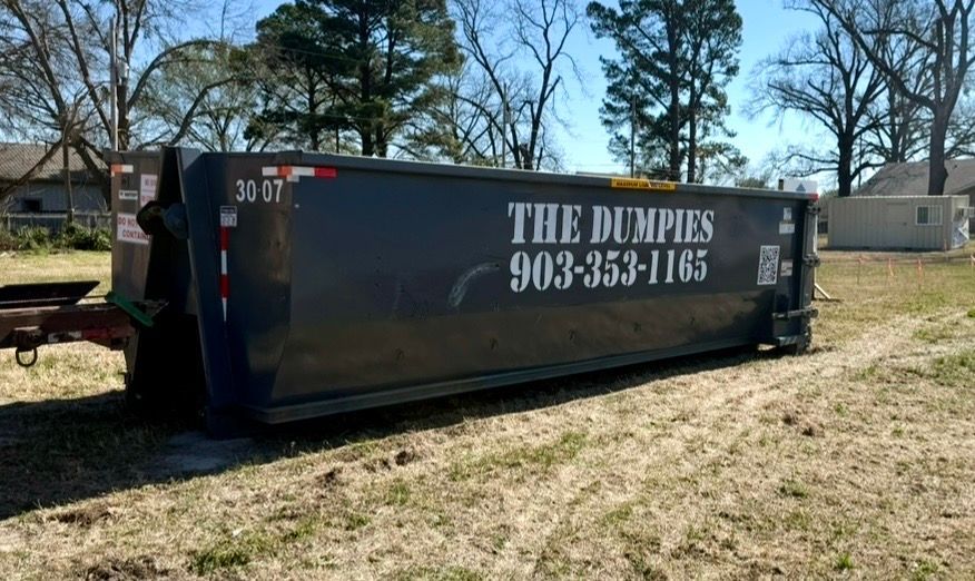 A truck is towing a trailer in a field.