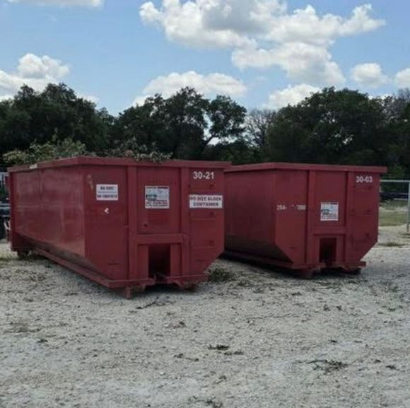 A truck is towing a trailer in a field.