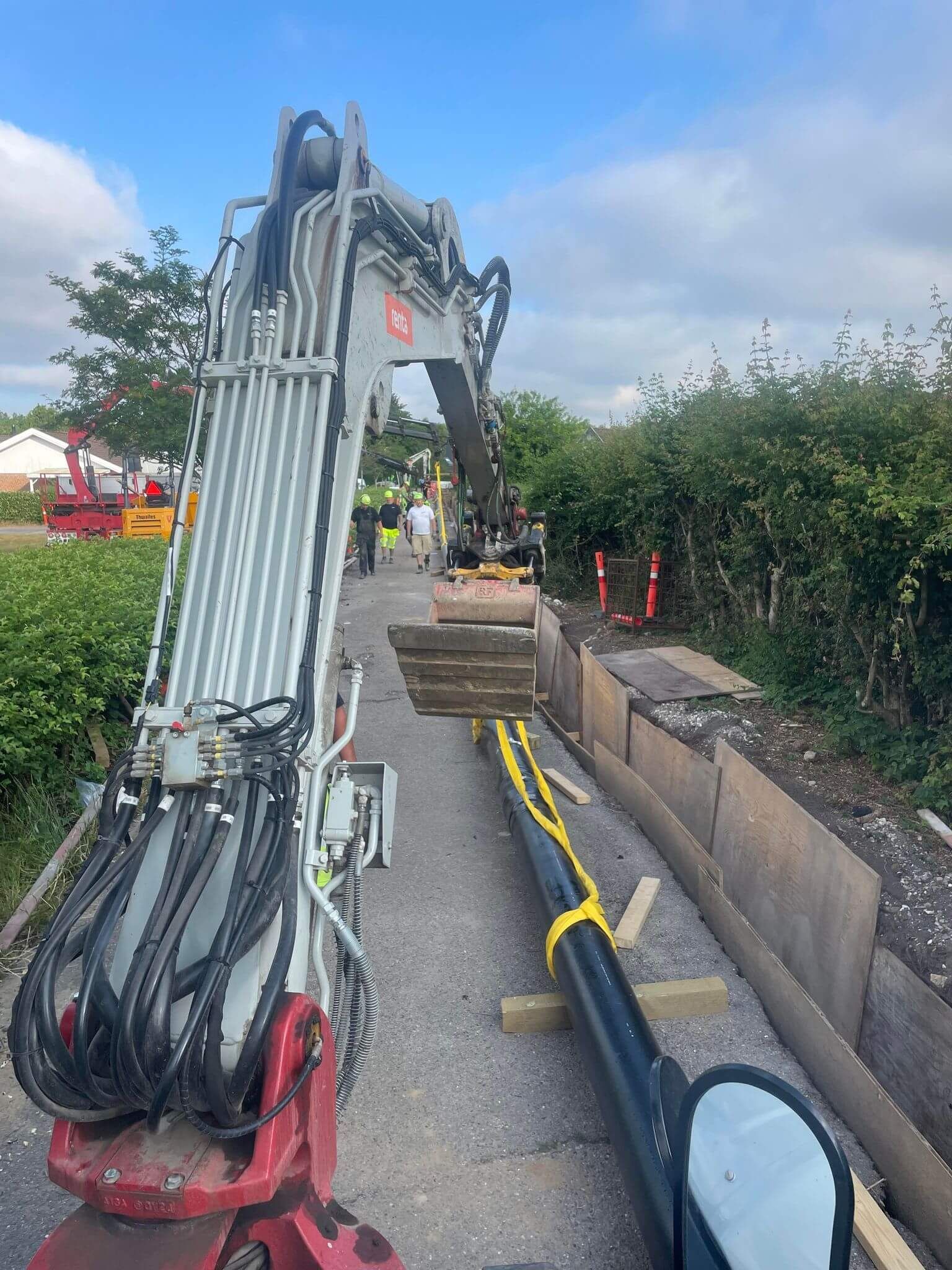 En kran sidder i siden af en vej ved siden af et rør.