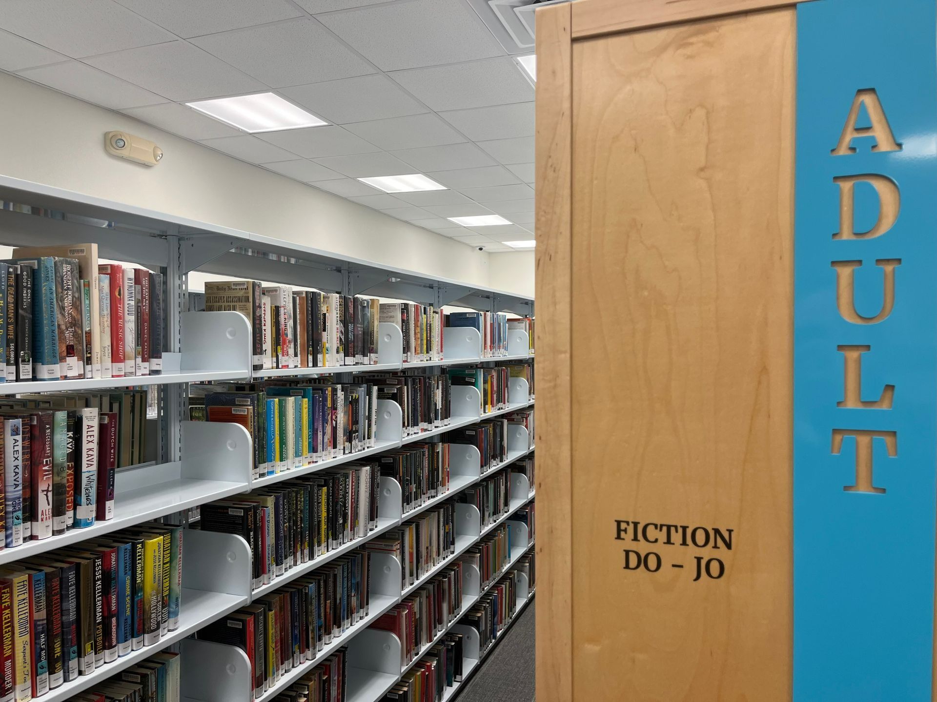Library shelves filled with books. Sign indicates