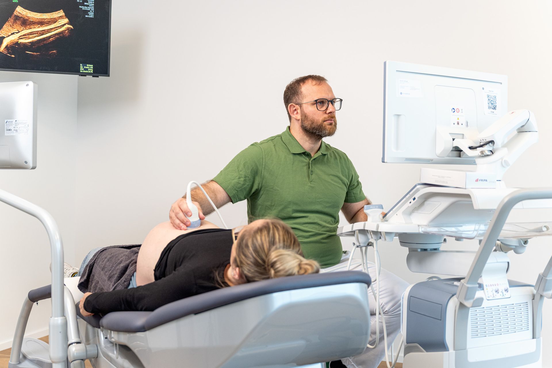 Ein Arzt und ein Patient schauen gemeinsam auf ein Tablet.