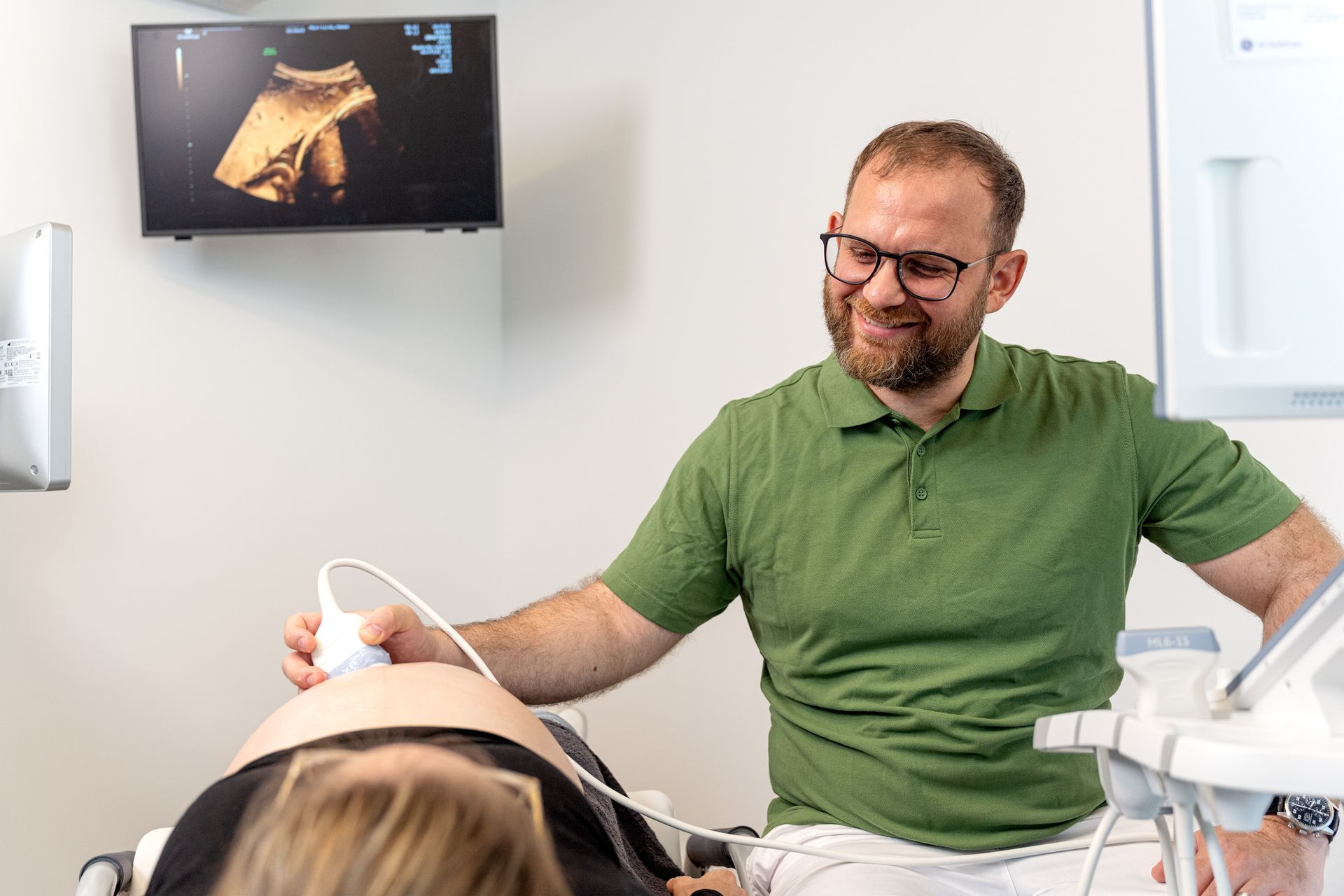 Ein Arzt und ein Patient schauen gemeinsam auf ein Tablet.