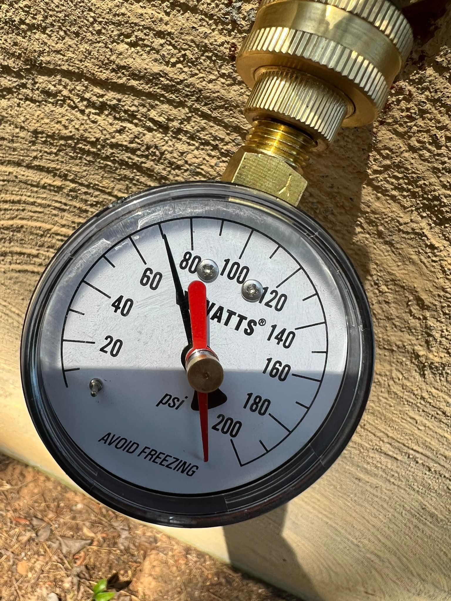 A close up of a pressure gauge attached to a pipe.