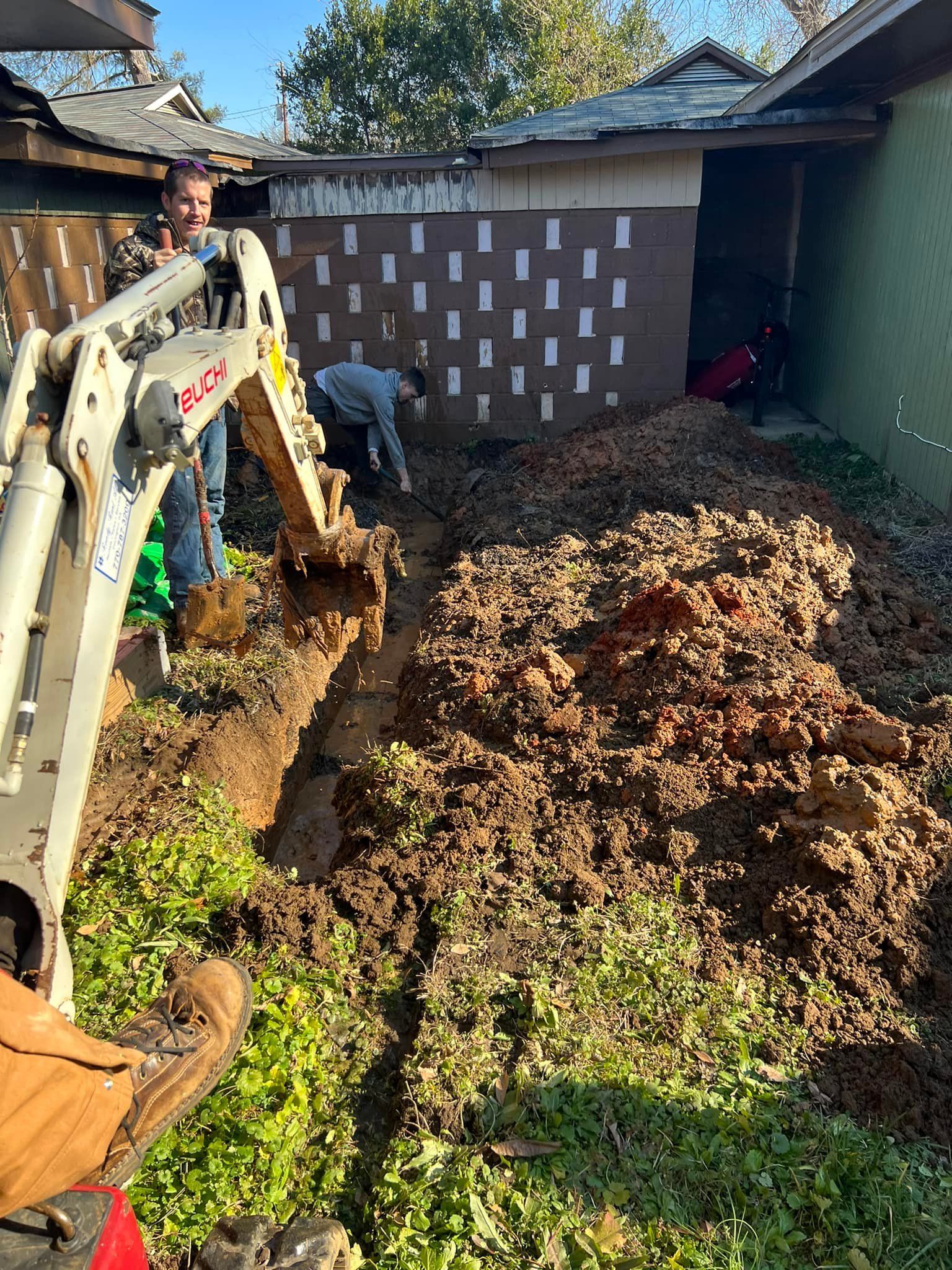 A man is using an excavator to dig a hole in the ground.
