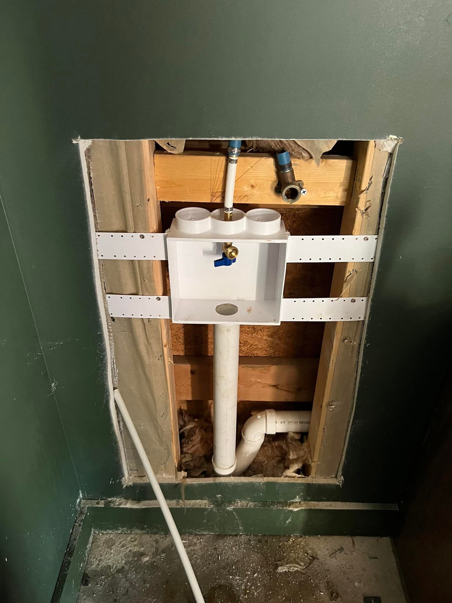 A bathroom sink is being installed in a hole in the wall.
