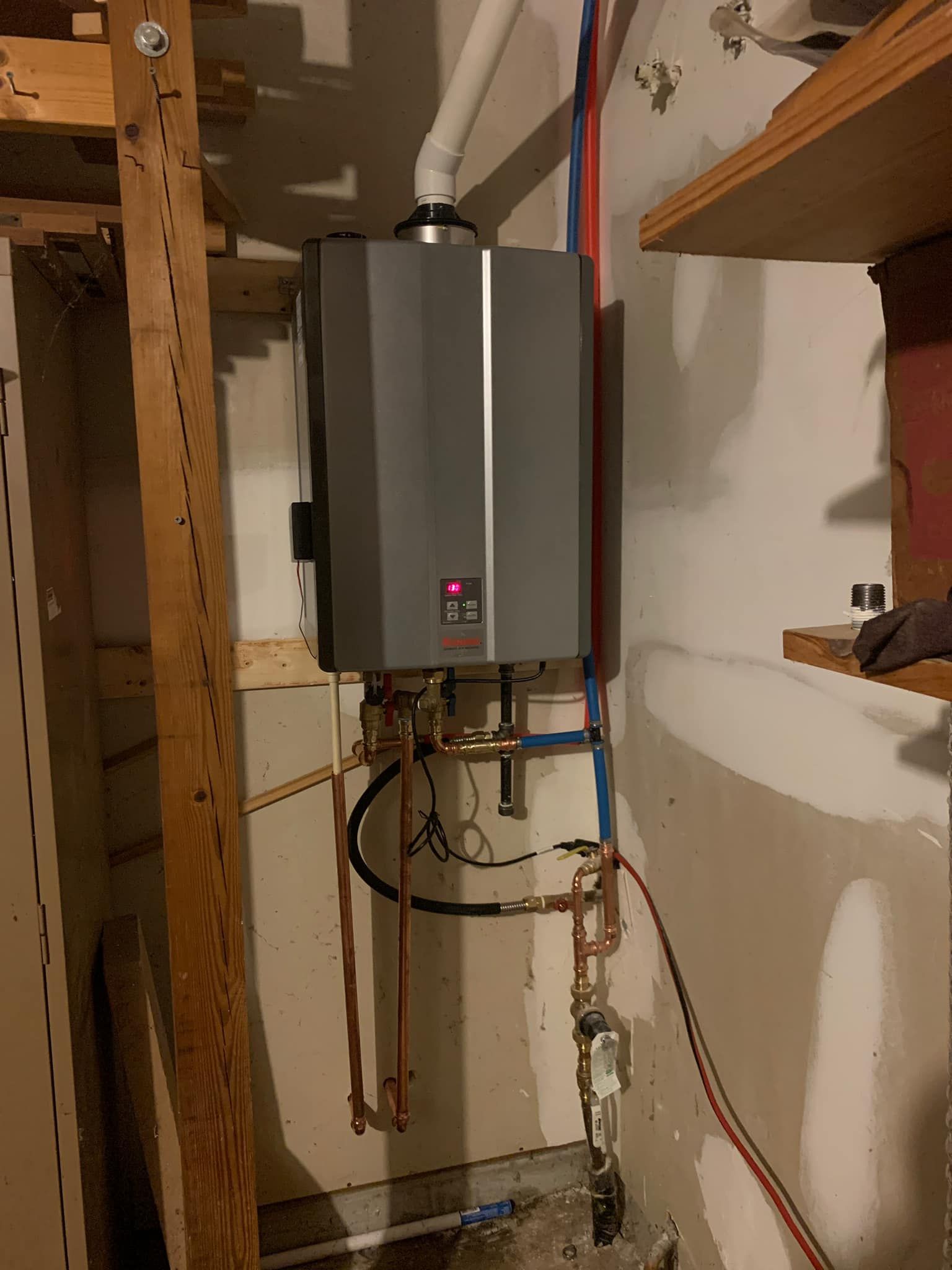 A water heater is hanging on a wall in a room.