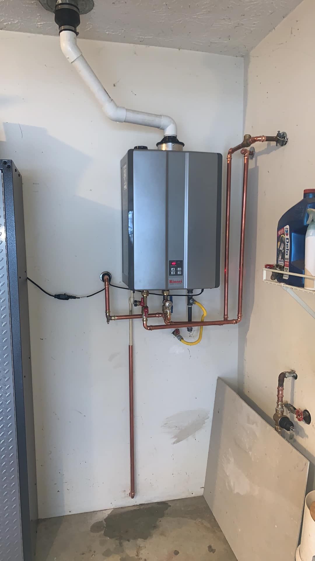 A water heater is hanging on a wall in a room.